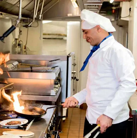 Hessler Heights Chef Created Meals, chef frying a dish.