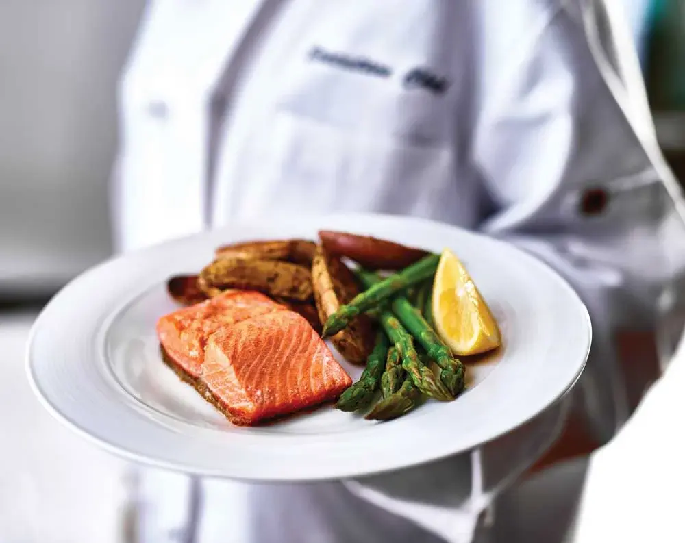 Hessler Heights Chef Created Meals, chef delivering a finished dish.